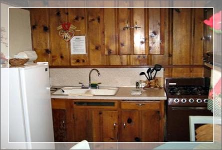 Kitchen with full refrigerator, microwave, coffee maker, pot pans and utensils